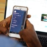 Digital marketing professional managing social media campaigns on mobile and laptop for branding and promotional services in Kochi.